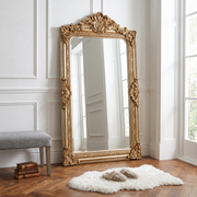 Hand-carved French Baroque full-length mirror in gold, shown in a bright room