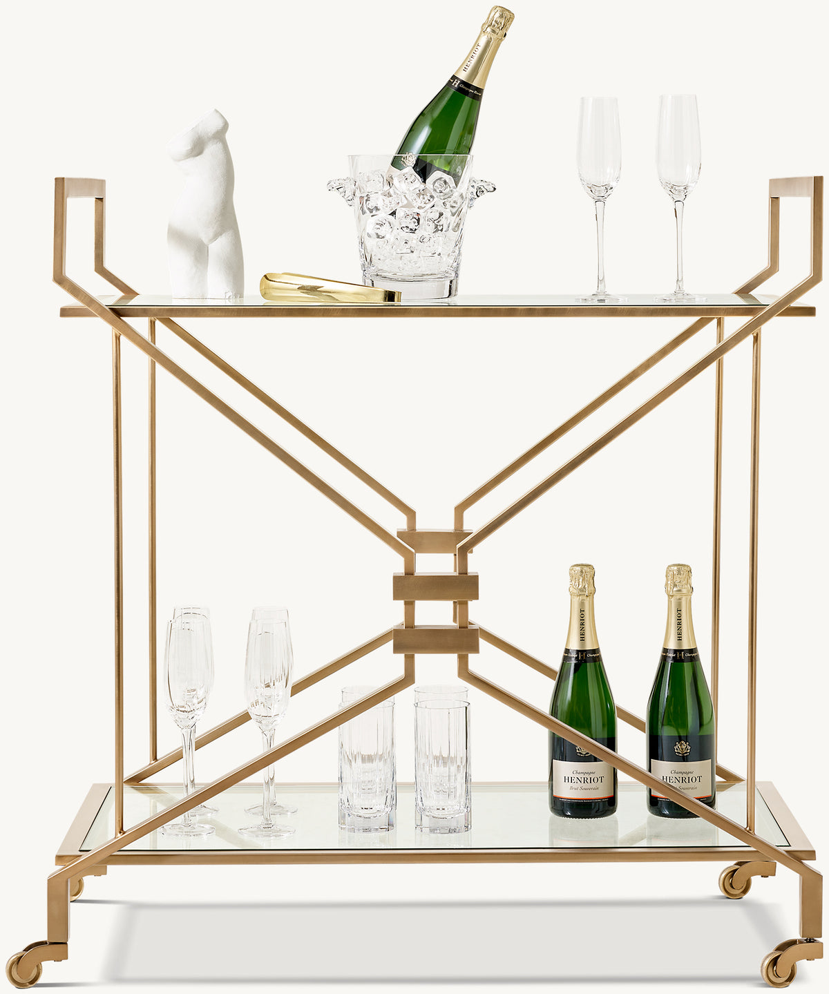 Charles Bar Cart – front view with glass shelves and a brass-toned frame styled with champagne and glasses