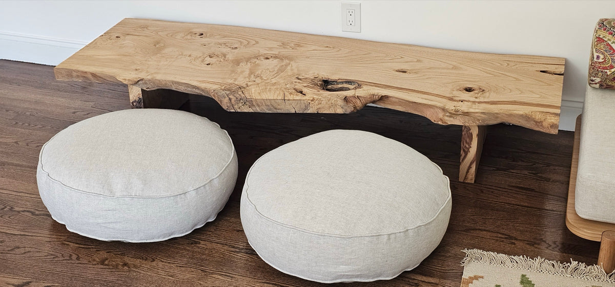 Live-edge wood bench with two floor cushions
