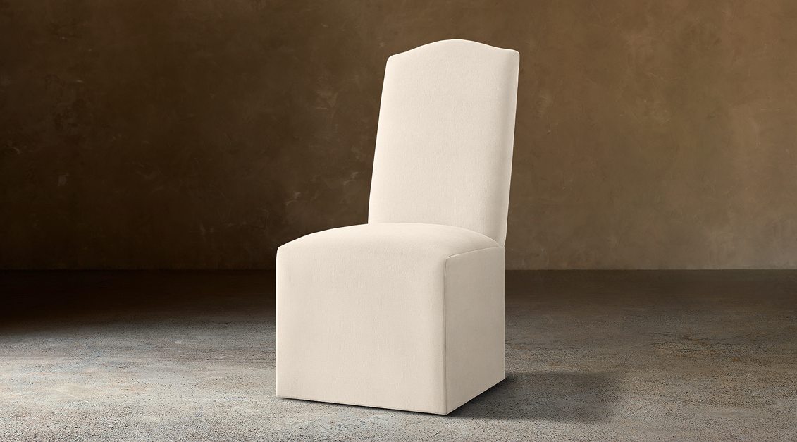 Alexandria Camelback Fabric Dining Side Chair – three-quarter view in natural-toned upholstery