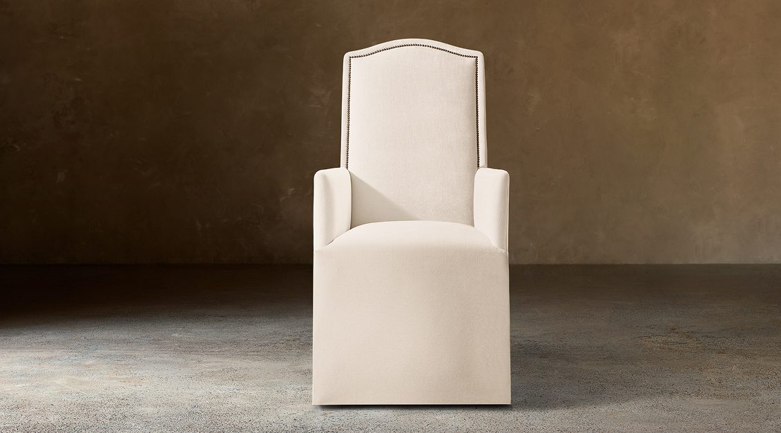 Alexandria Camelback Fabric Dining Armchair With Nailheads – front view in natural-toned upholstery