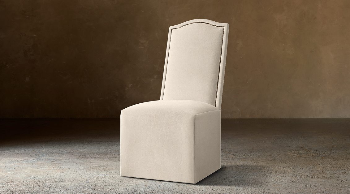 Alexandria Camelback Fabric Dining Side Chair With Nailheads – three-quarter view in natural-toned upholstery